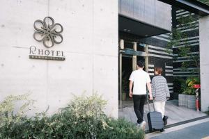 大阪R Hotel Namba South的走出酒店走的男人和女人