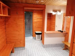 鲁卡Vuosselin Helmi Apartments的浴室设有木墙和白色瓷砖地板。