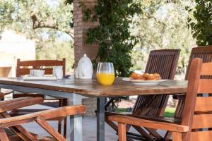 安波拉Santolina - Casa Rural en l'Ampolla con piscina privada, jardín y barbacoa - Deltavacaciones的一张木桌,上面放着一盘食物和橙汁