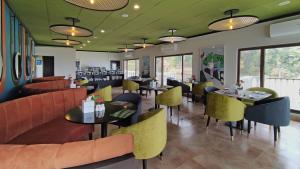 穆里The Vibe By Ambiance的餐厅配有沙发、桌子和黄色椅子