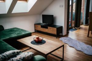 上陶恩Alpenhotel & Aparthotel Lanz的客厅配有绿色沙发和电视