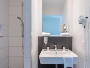 慕尼黑B&B Hotel München-Trudering的浴室配有白色水槽和淋浴。