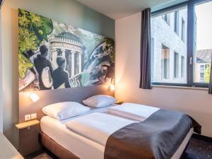 慕尼黑B&B Hotel München-Trudering的一间卧室配有一张壁画大床