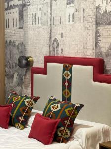 塞维利亚Posada de los Venerables的一张带红色和白色床头板和枕头的床
