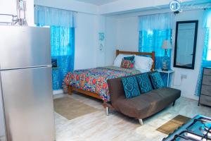 Arnos ValePRI Studio Apartment的蓝色卧室配有床和冰箱