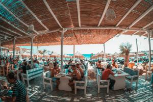 天堂海滩海滩露营帕拉迪斯酒店的一群坐在海滩桌子上的人