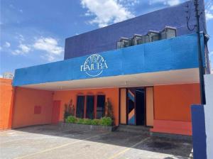 戈亚尼亚Itajubá Classic Hotel Goiânia的一座橙色和蓝色的建筑,上面有标志