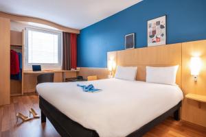 日内瓦日内瓦国家中心宜必思酒店的一张位于带白色大床的房间的床铺