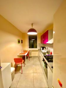 克拉科夫Cheap entire apartment in a super location的厨房配有桌子和红色椅子