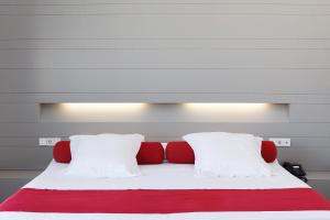 拉斯内格拉斯卡拉格兰德卡博德佳塔水疗酒店的一张带红色和白色枕头的床