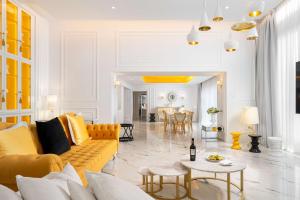 布加勒斯特布加勒斯特丽笙酒店的客厅配有黄色的沙发和桌子