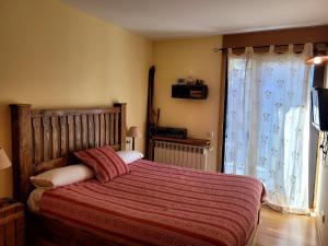 维耶拉Vielha centro apartamento eraval的一间卧室配有一张带红色毯子的床和窗户。