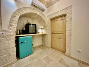 阿尔贝罗贝洛Trulli Contento - Rooms & Apartments的一间设有门的房间,厨房里配有蓝色冰箱