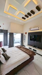 马迪凯里kollanoor guest house的一间大卧室,配有一张大床和一台平面电视