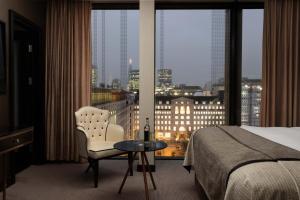 伦敦Montcalm Royal London House, London City的酒店客房设有床、桌子和窗户。