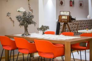 雅典美家园酒店的一张桌子、橙色椅子和摄像头