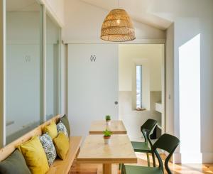 蓬塔德尔加达Sky PDL的用餐室配有木桌和黄色枕头