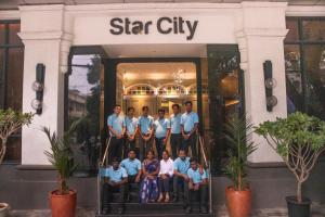 钦奈Hotel Star City的一群站在明星城市建筑前的人