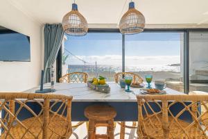 La JacaBrisa Marina的一间带桌椅和大窗户的用餐室