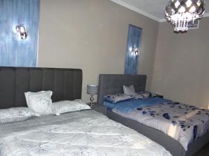 迪拜Huge Entire apartment for Couples ,families & Groups -up to 5 Guests- with free pool, steam & Sauna ,JVC,Dubai的一间卧室配有两张床和吊灯。