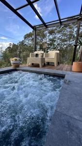 袋鼠谷Mike's Kangaroo Valley的房屋内带桌椅的游泳池