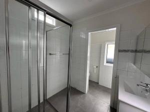 悉尼2 Bedroom Darling Harbour - Pyrmont 2 E-Bikes Included的一间带玻璃淋浴和水槽的浴室