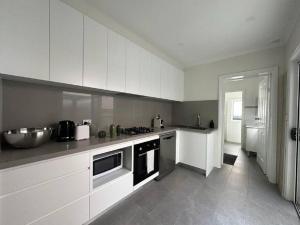 悉尼2 Bedroom Darling Harbour - Pyrmont 2 E-Bikes Included的厨房配有白色橱柜和水槽