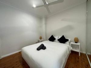 悉尼2 Bedroom Darling Harbour - Pyrmont 2 E-Bikes Included的卧室配有带黑色枕头的白色床