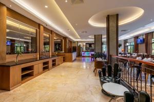 坎帕拉Best Western Plus The Athena Hotel Kampala的餐厅设有酒吧,配有桌椅