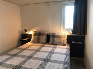 OpheusdenVakantiehuis voor 4 personen的一间卧室配有一张带拼盘床罩的床和窗户。