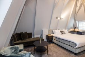 阿姆斯特丹Maison ELLE Amsterdam的一间卧室配有一张床、一张沙发和一把椅子