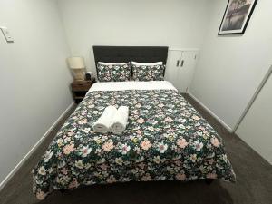 奥克兰Trafalgar Place的一间卧室配有一张床,上面有两条毛巾