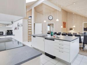 博托比24 person holiday home in Idestrup的厨房配有白色橱柜和墙上的时钟