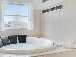博托比24 person holiday home in Idestrup的白色的浴室设有浴缸和窗户。