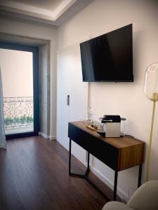 维拉·普拉亚·德·安科拉BLUE ANCORA HOTEL的一间设有一张桌子的房间,墙上配有电视