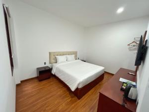 邦美蜀Ban Me Central Hotel 2的卧室配有白色的床和书桌