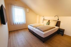 BrackenheimBiohof Döbler Ferienwohnungen的一间卧室设有一张床、一个窗口和一台电视