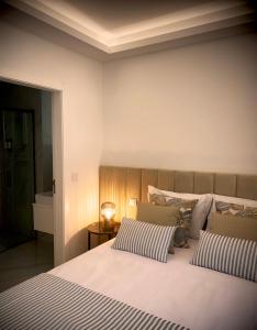 维拉·普拉亚·德·安科拉BLUE ANCORA HOTEL的卧室配有带条纹枕头的白色大床