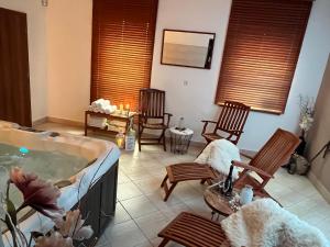 利托福卡西尼克Wellness Villa Liptov的客厅设有热水浴缸和摇椅