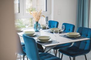 奥斯特菲尔登FiNEST Design Stuttgart Airport Messe的一张带蓝色椅子的餐桌和鲜花花瓶