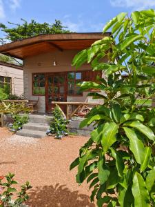 NarokEmirishoi Cottages and Garden Bistro的前面有树门廊的房子
