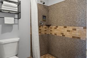 奥克兰清风湾酒店的带淋浴、卫生间和毛巾的浴室