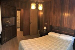 马斯帕洛马斯Casa Inmaculada的一间卧室设有一张床和木镶板墙