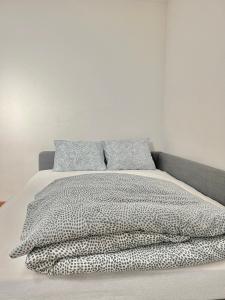 RudolfstettenAppartamento per 4 persone的一张带黑白棉被和枕头的床
