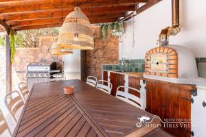 奥利维拉Charming Villa Del Cel, peaceful location, private pool and A/C的厨房配有木桌和炉灶。