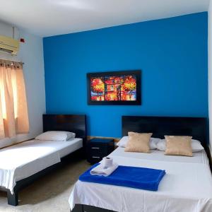 阿瓜奇卡HOTEL LUZ MERY的蓝色墙壁客房的两张床