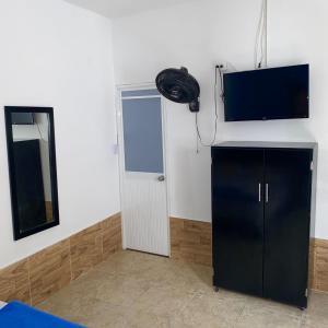阿瓜奇卡HOTEL LUZ MERY的一间设有黑色橱柜和平面电视的客房