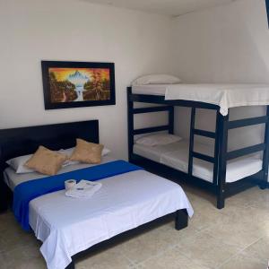 阿瓜奇卡HOTEL LUZ MERY的客房设有两张双层床和一张床。