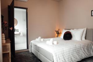 恩斯赫德Hotel bij Jacob的卧室配有一张带镜子的白色床