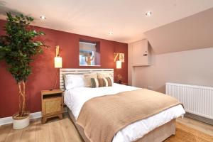利兹Homebird Property - Haddon House的一间卧室设有一张带红色墙壁的大床